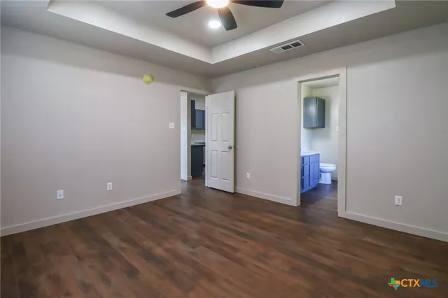 a view of an empty room with wooden floor