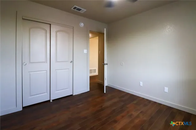 a view of an empty room with wooden floor