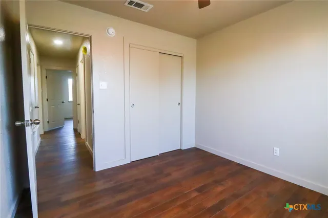 a view of a hallway with wooden floor