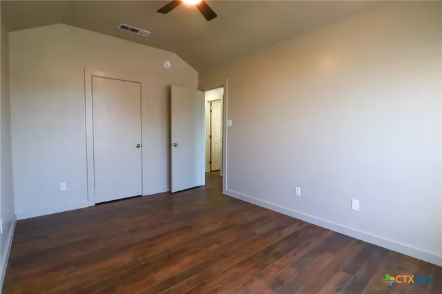 a view of an empty room with wooden floor