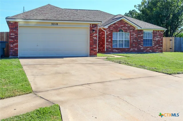a front view of a house with a garden and yard