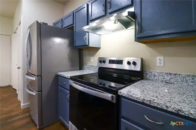 a kitchen with stainless steel appliances granite countertop a stove and a refrigerator