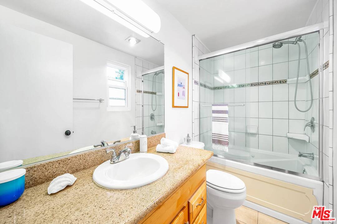 13035 Mindanao Way, Unit 2 Marina del Rey, CA 90292 - Photo 18 of 29 a bathroom with a granite countertop sink toilet a mirror and shower