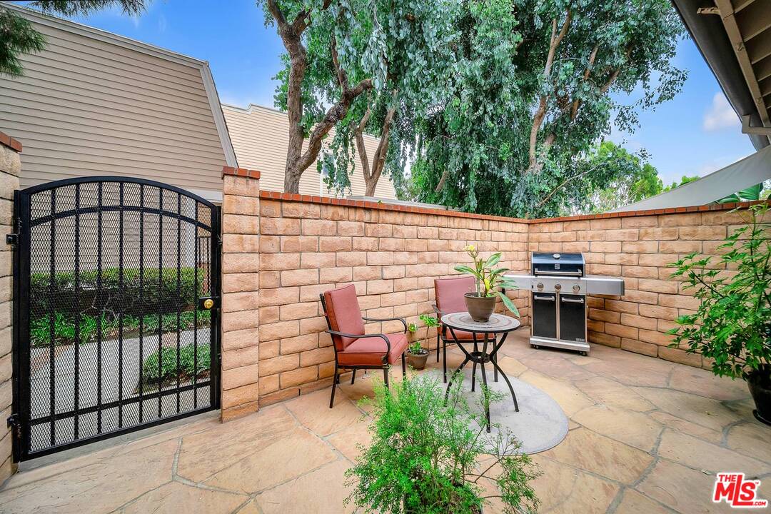13035 Mindanao Way, Unit 2 Marina del Rey, CA 90292 - Photo 22 of 29 a view of a patio with table and chairs with wooden fence and plants