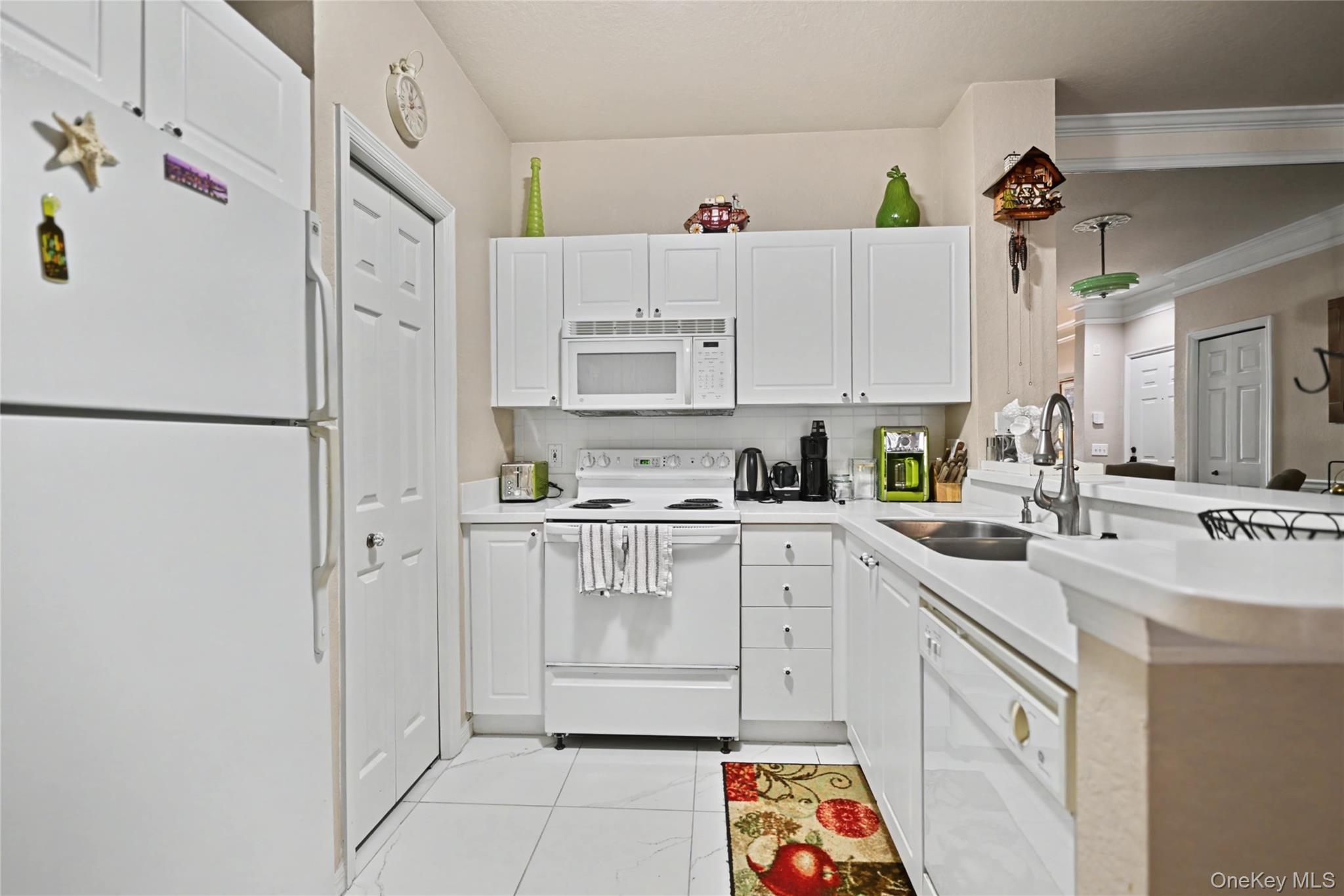 5174 Northridge Road, Unit 211 Sarasota, FL 34238 - Photo 6 of 29 a kitchen with white cabinets and white appliances