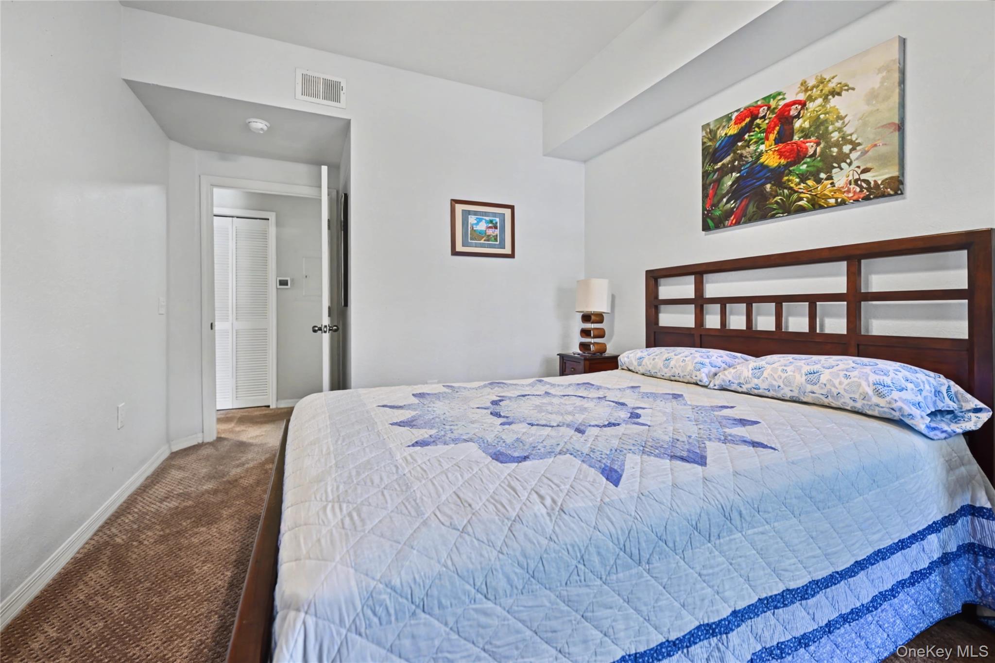 5174 Northridge Road, Unit 211 Sarasota, FL 34238 - Photo 10 of 29 a bedroom with a bed and painting on the wall