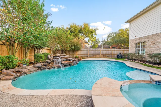 a view of a swimming pool with a patio and a yard