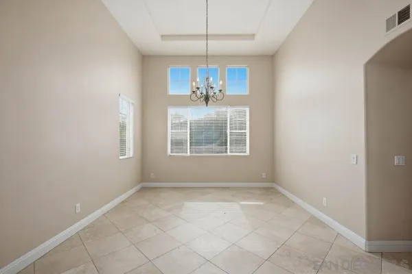 an empty room with windows and chandelier