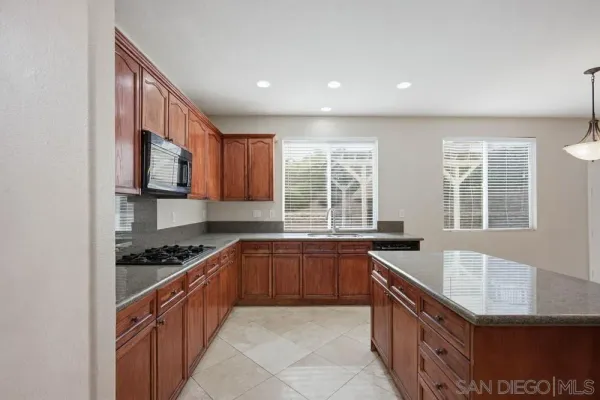 a large kitchen with stainless steel appliances granite countertop a sink and a stove