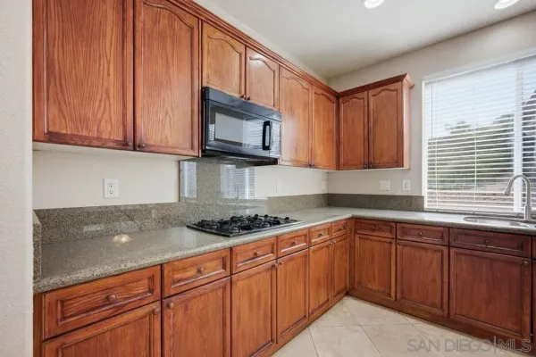 a kitchen with stainless steel appliances granite countertop a sink stove and microwave