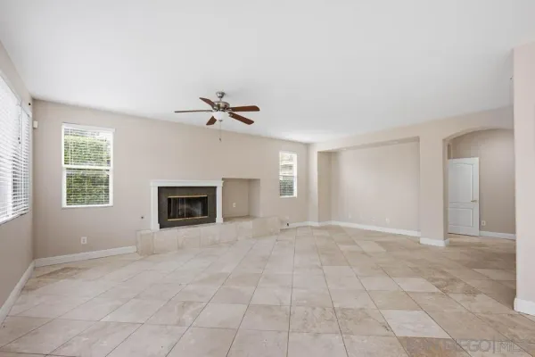 a view of an empty room with a fireplace and a window