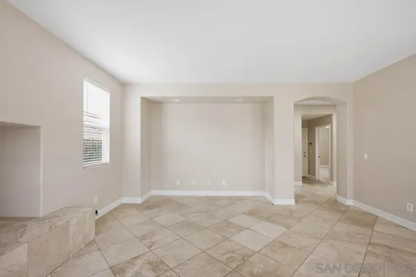 a view of an empty room with window and closet area