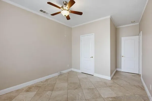 an empty room with closet and a chandelier fan