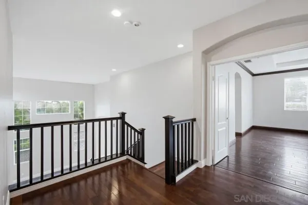 a view of hallway with wooden floor and stairs