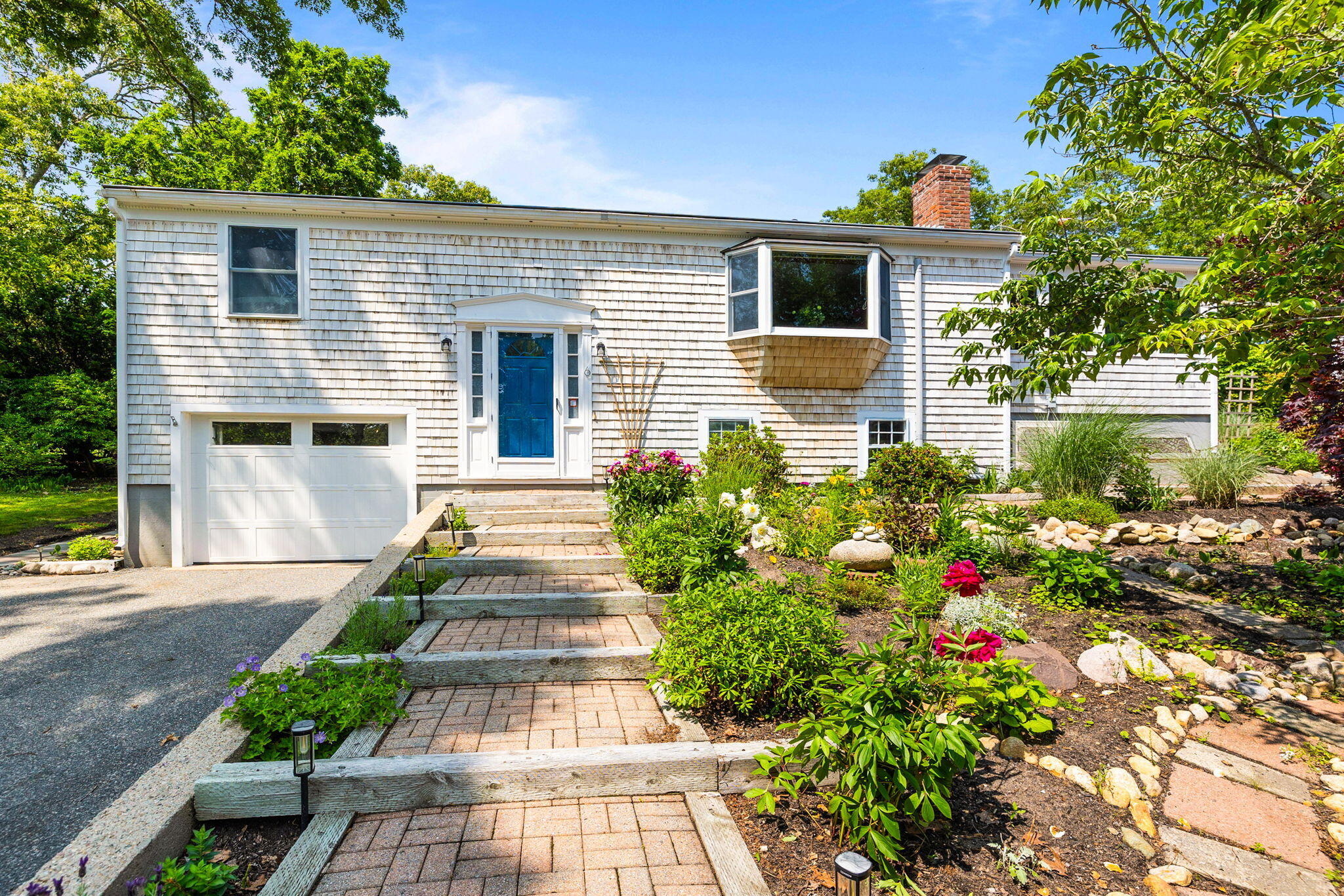 6 Paddock Drive Harwich, MA 02645 - Photo 3 of 40 a front view of a house with a yard and a garden