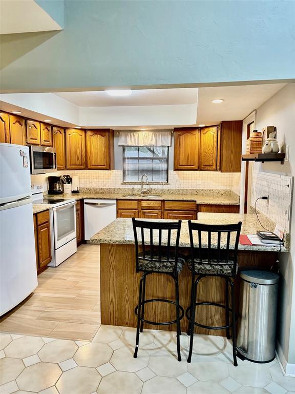 19807 Southwest 85th Loop Dunnellon, FL 34432 - Photo 23 of 60 a kitchen with stainless steel appliances kitchen island granite countertop a table chairs sink and cabinets