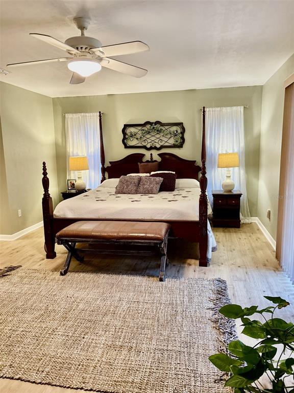 19807 Southwest 85th Loop Dunnellon, FL 34432 - Photo 32 of 60 a bedroom with a bed lamp and wooden floor