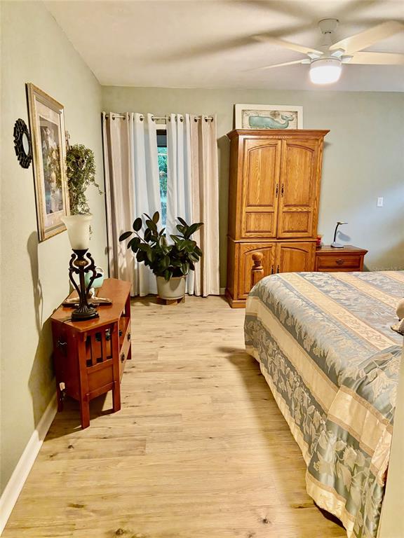 19807 Southwest 85th Loop Dunnellon, FL 34432 - Photo 44 of 60 a bedroom with a bed and wooden floor