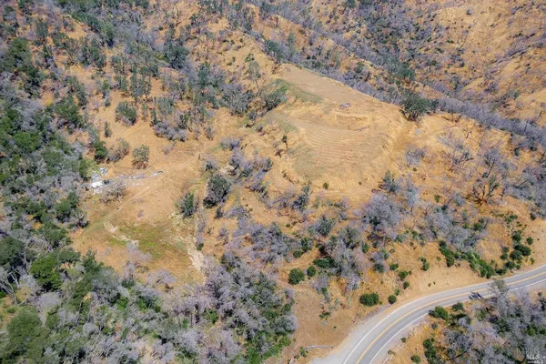 a view of a dry yard with mountains in the background