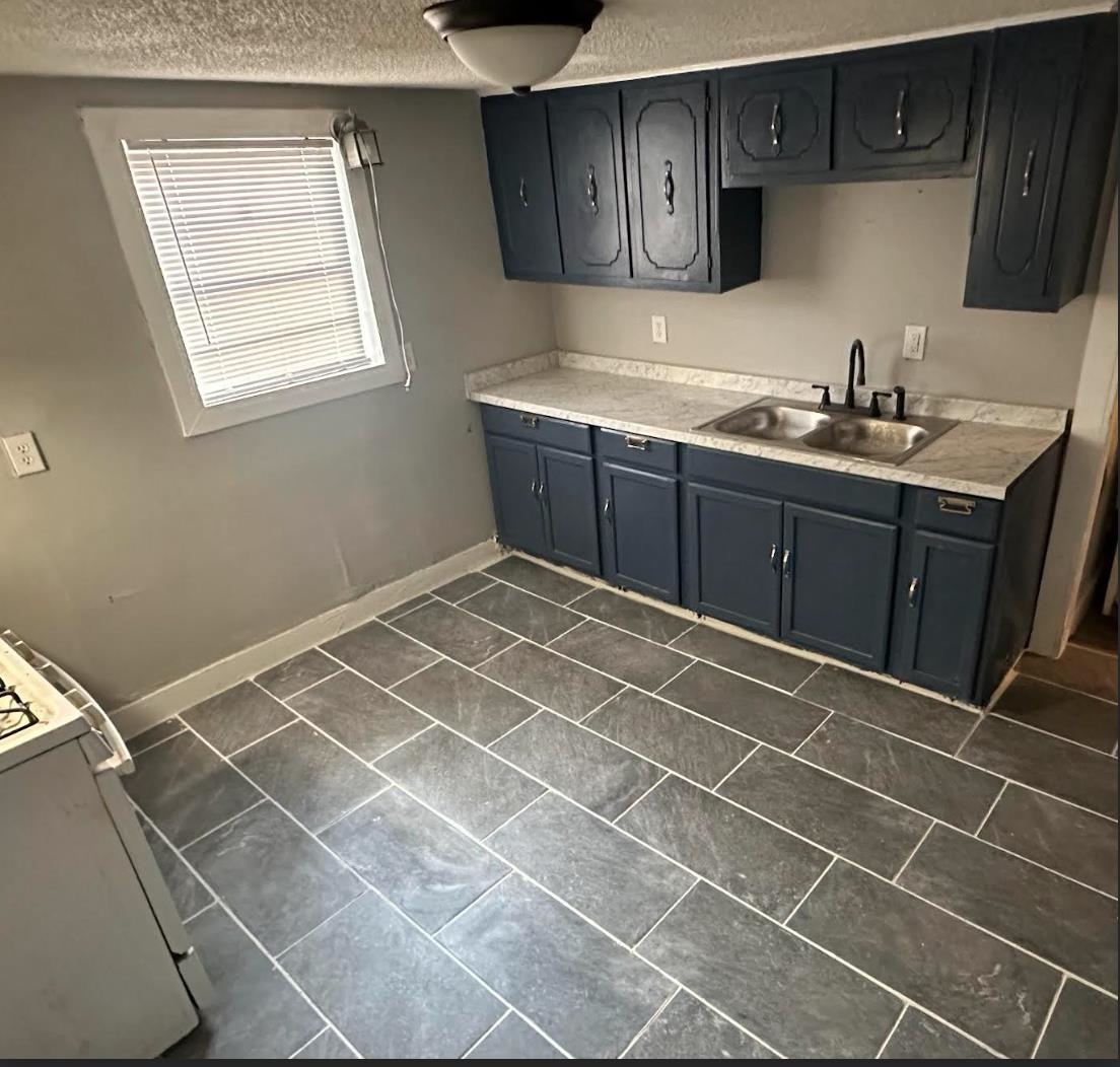 3579 Kendrick Road Memphis, TN 38108 - Photo 2 of 8 Kitchen featuring a textured ceiling, white range, and sink
