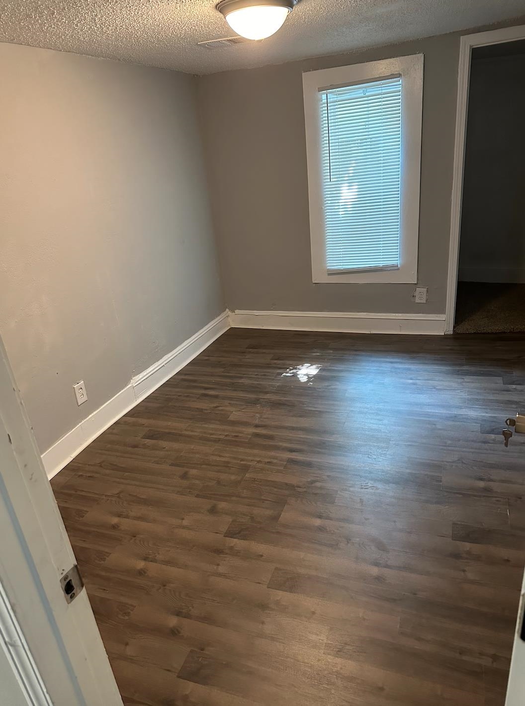 3579 Kendrick Road Memphis, TN 38108 - Photo 5 of 8 Empty room with dark wood-type flooring and a textured ceiling
