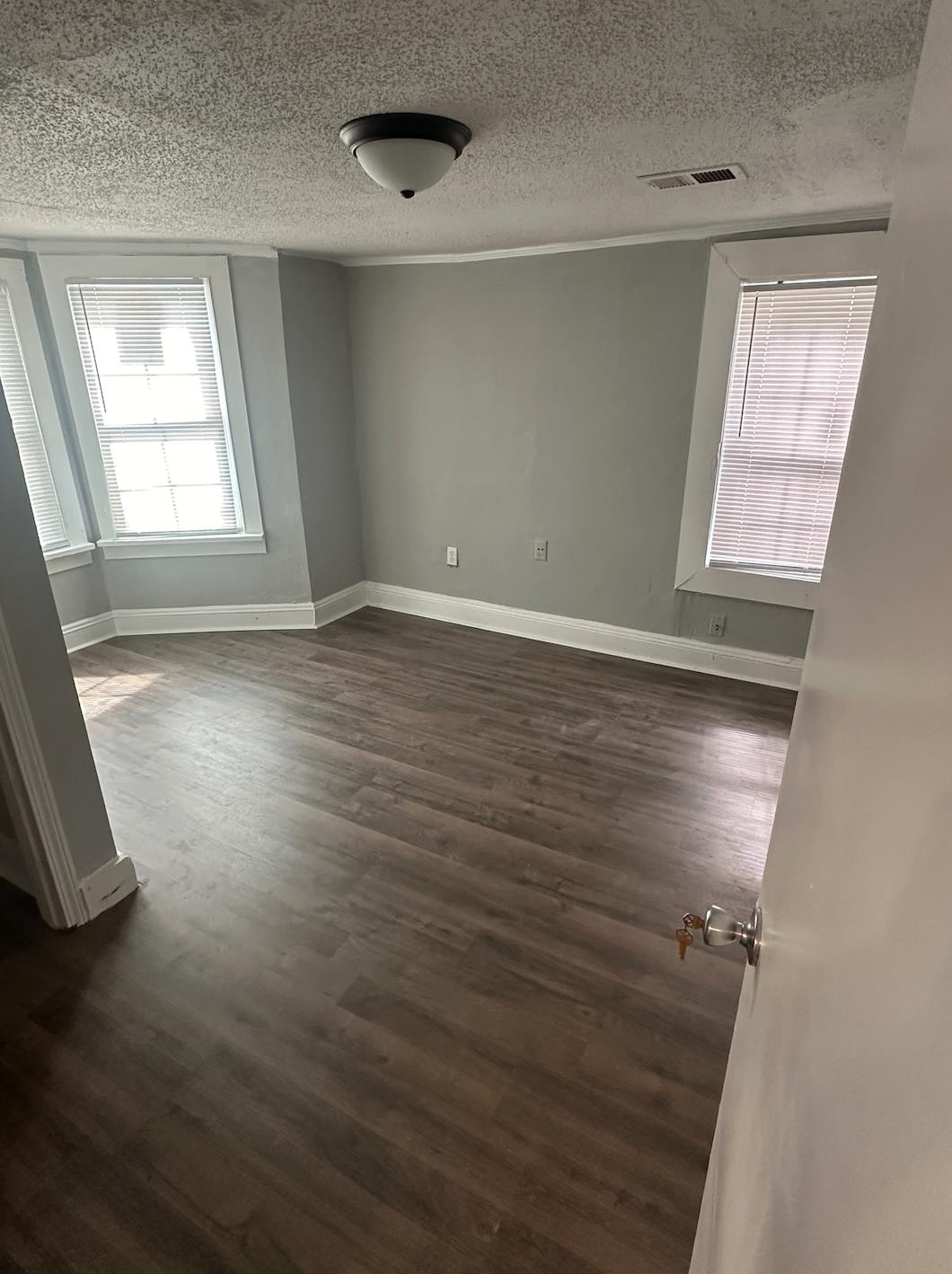 3579 Kendrick Road Memphis, TN 38108 - Photo 6 of 8 Empty room with a textured ceiling and dark hardwood / wood-style floors