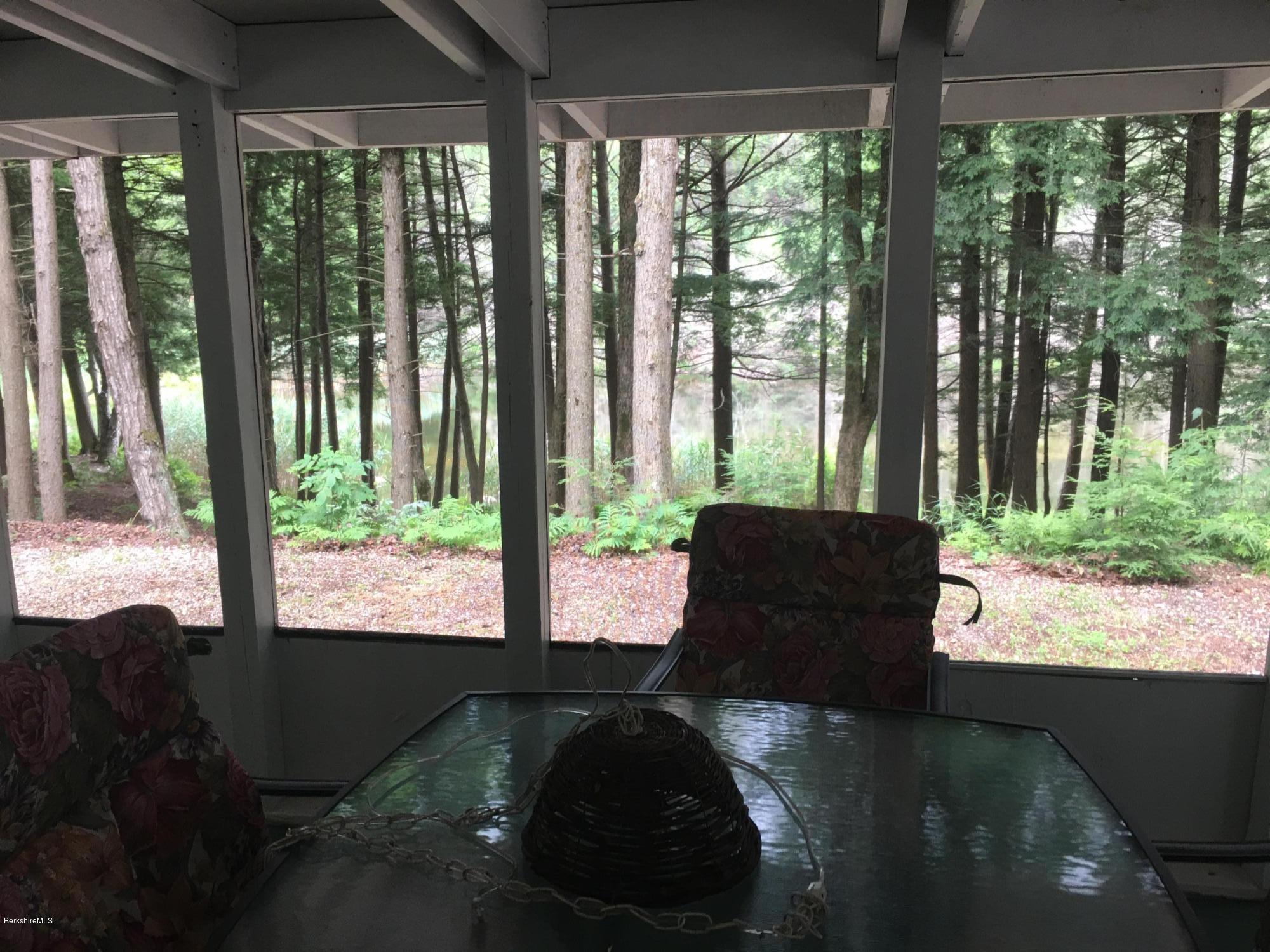 7 North Main Road Otis, MA 01253 - Photo 3 of 24 a living room with large trees and a floor to ceiling window