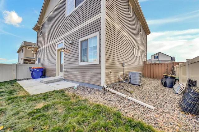 a front view of a house with barbeque and wooden fence