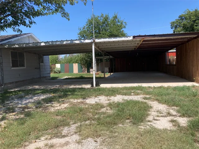 a view of a house with backyard and a tree