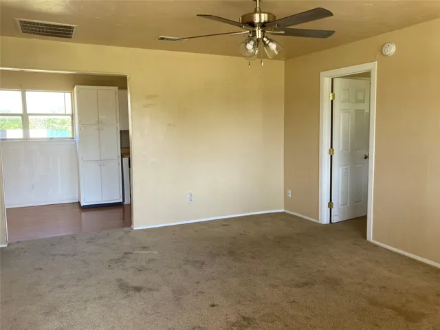 an empty room with closet and a chandelier fan