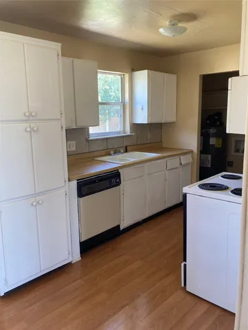 a kitchen with a sink cabinets and wooden floor