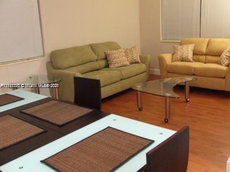 635 83rd Street, Unit 47 Miami Beach, FL 33141 - Photo 1 of 16 a living room with furniture and a wooden floor