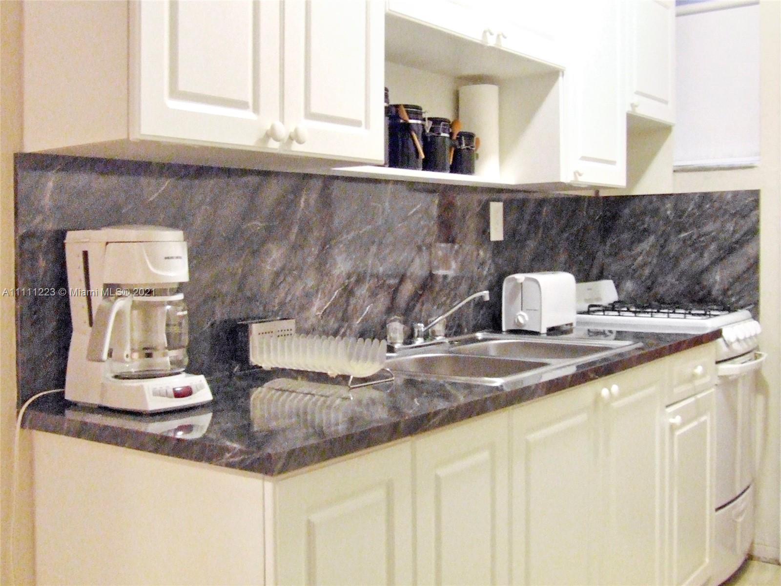 635 83rd Street, Unit 47 Miami Beach, FL 33141 - Photo 4 of 16 a kitchen with a sink a stove and cabinets