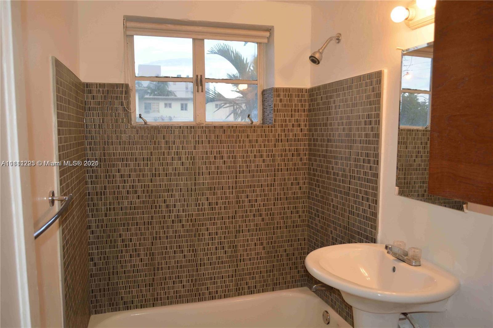 635 83rd Street, Unit 47 Miami Beach, FL 33141 - Photo 6 of 16 a bathroom with a sink a toilet and mirror