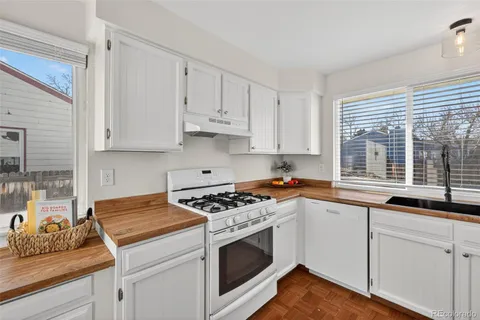 a kitchen with granite countertop white cabinets and white appliances