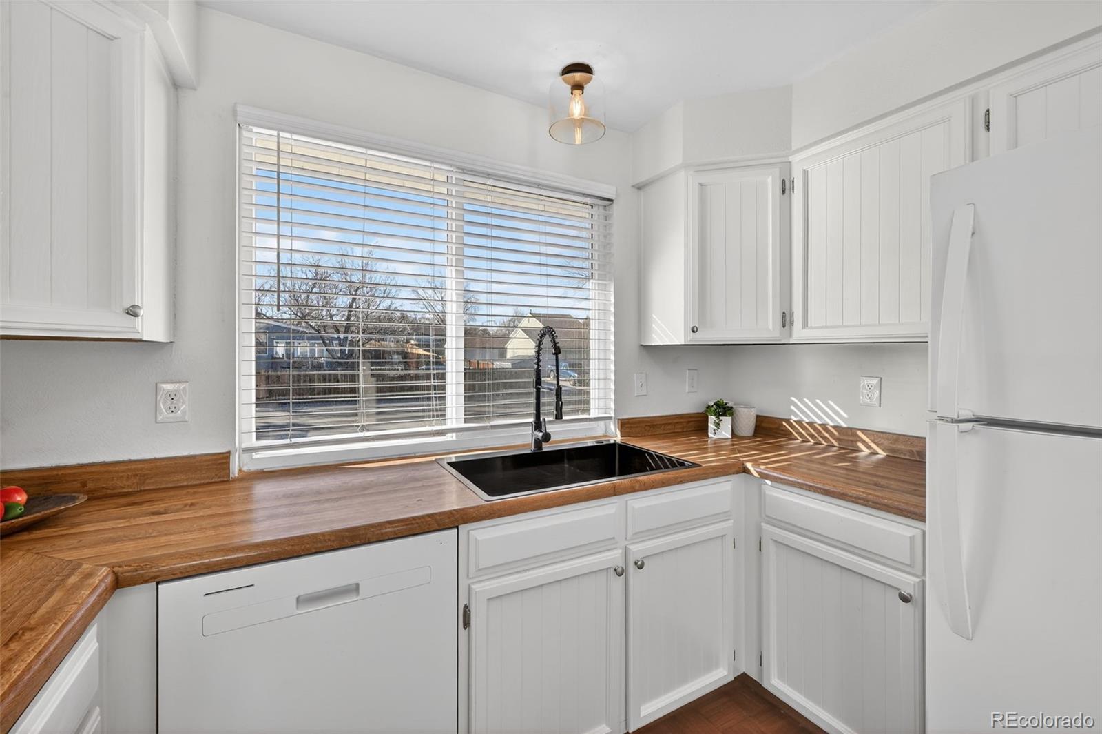 7586 Chase Street Arvada, CO 80003 - Photo 13 of 35 a kitchen with stainless steel appliances granite countertop white cabinets and a counter top space