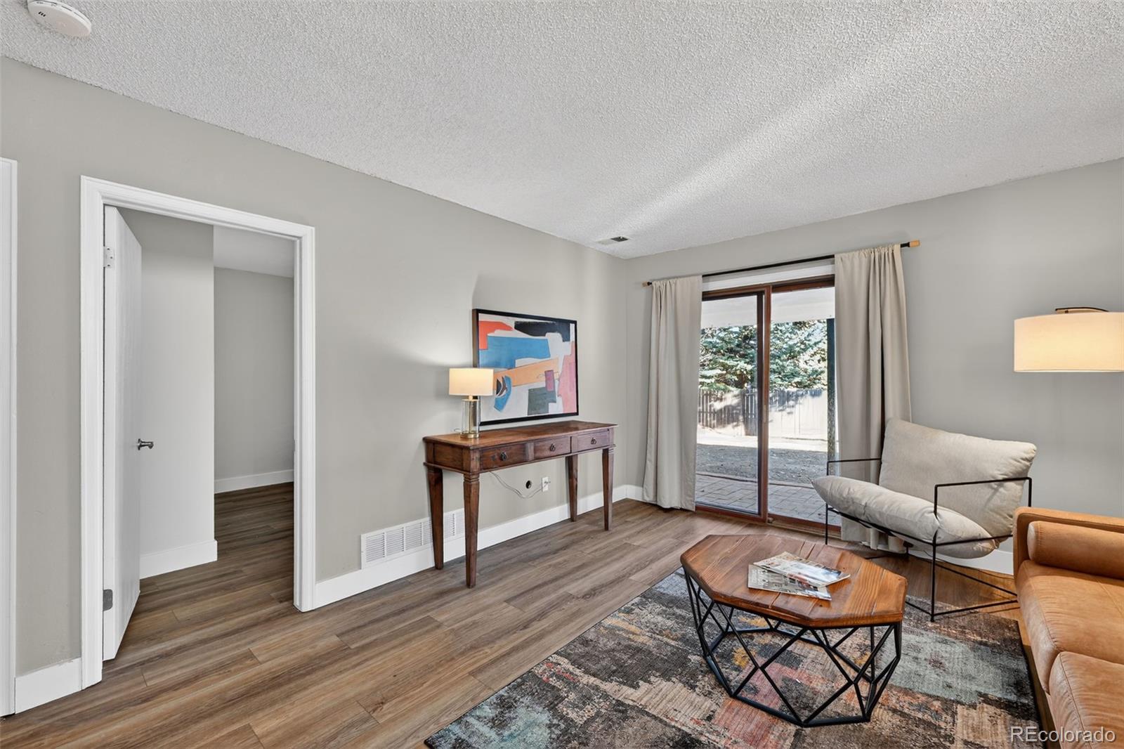 7586 Chase Street Arvada, CO 80003 - Photo 16 of 35 a living room with furniture and a wooden floor