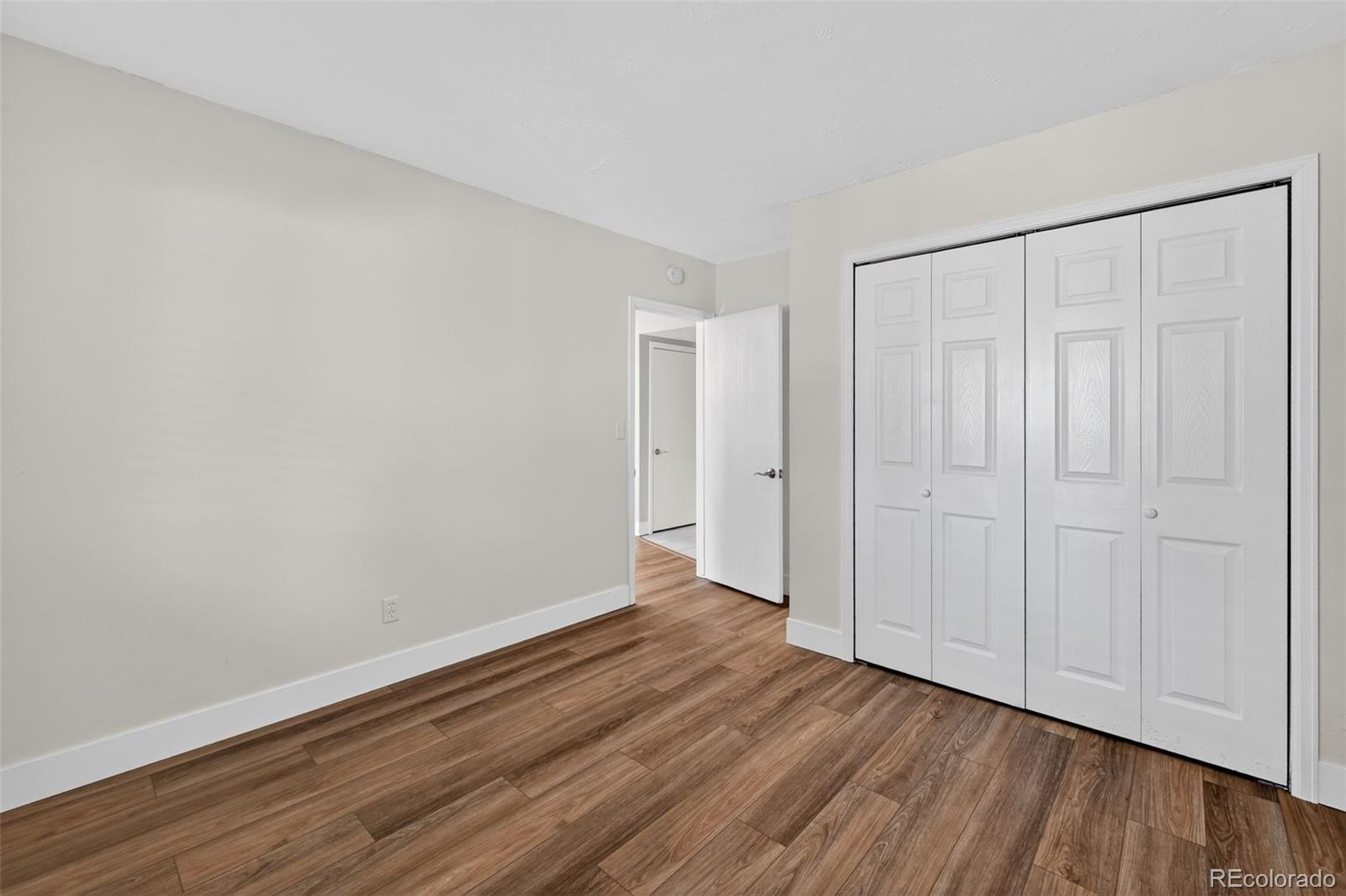 7586 Chase Street Arvada, CO 80003 - Photo 19 of 35 a view of an empty room with wooden floor
