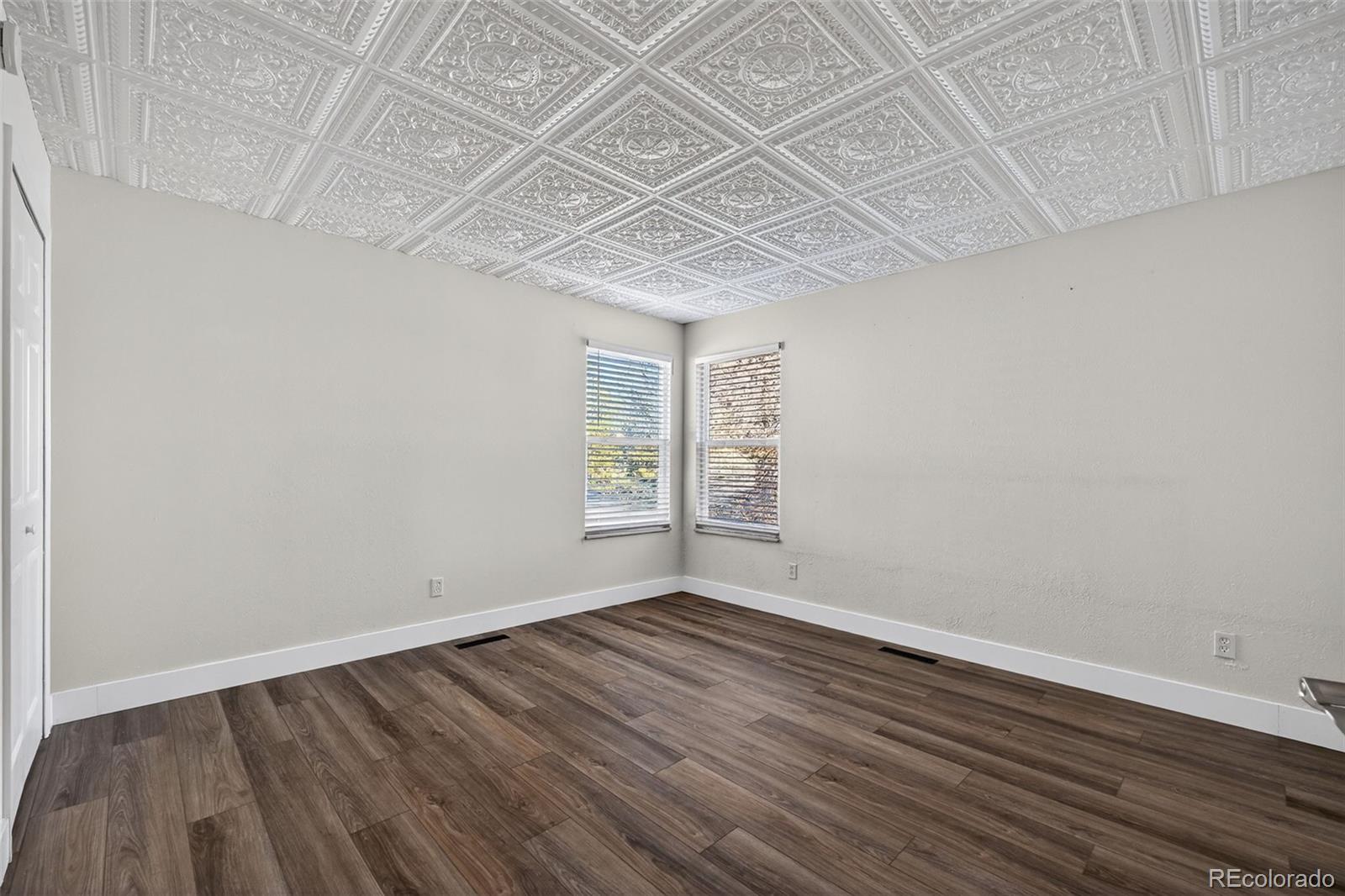 7586 Chase Street Arvada, CO 80003 - Photo 21 of 35 an empty room with wooden floor and windows