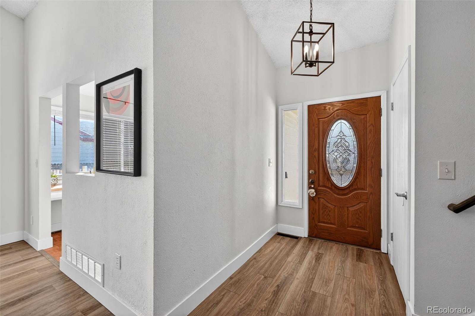 7586 Chase Street Arvada, CO 80003 - Photo 4 of 35 a view of a hallway with wooden floor