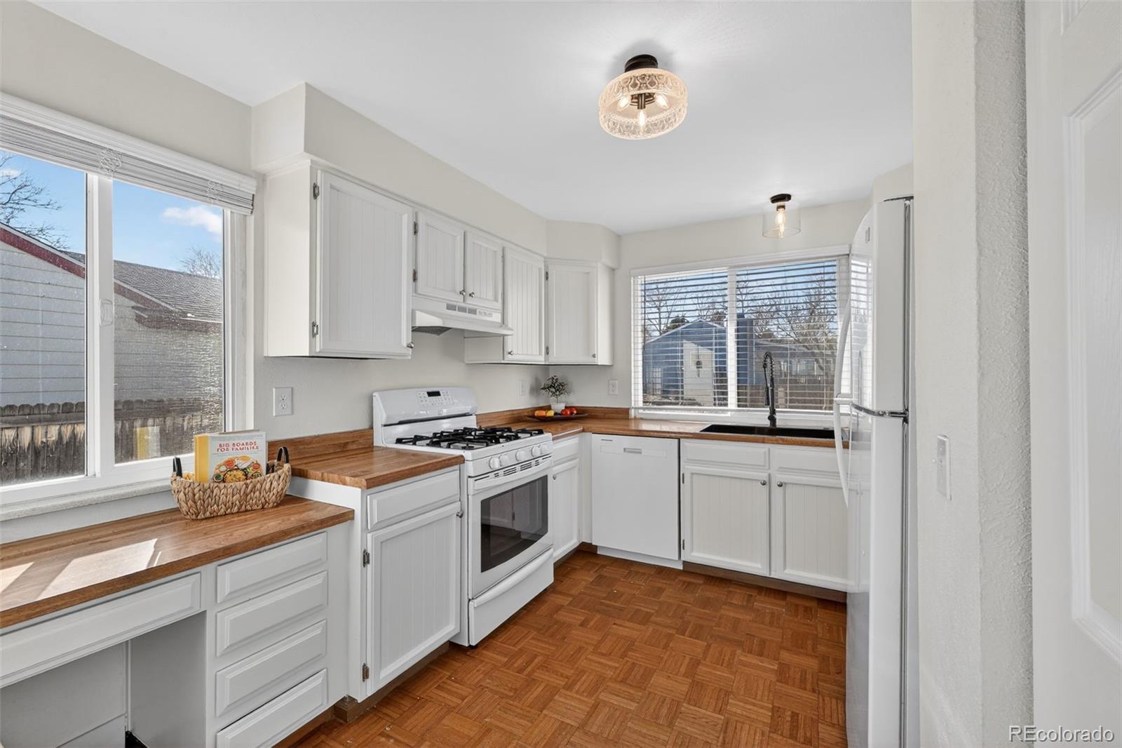 7586 Chase Street Arvada, CO 80003 - Photo 10 of 35 a kitchen with a stove a sink and a window