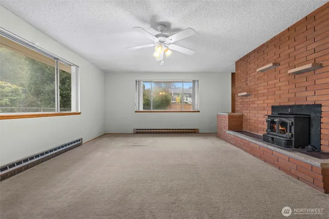 an empty room with windows and fireplace