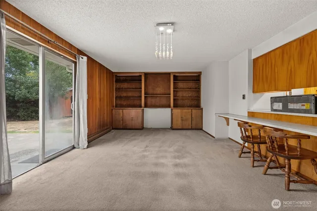 an empty room with windows and cabinet