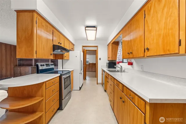 a large kitchen with stainless steel appliances granite countertop a large window and a kitchen