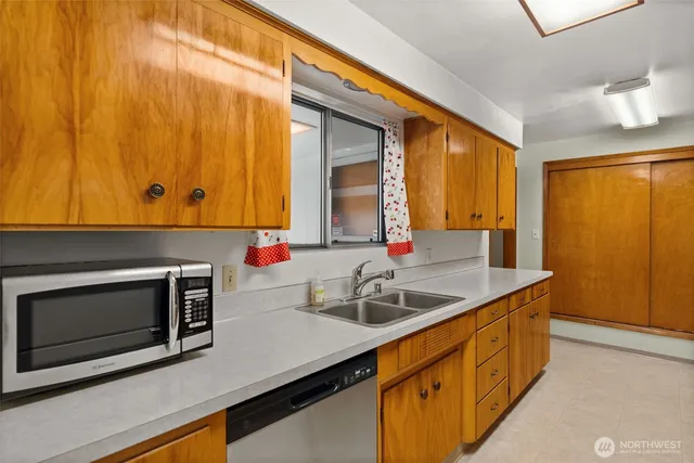 a kitchen with stainless steel appliances granite countertop a sink and a microwave