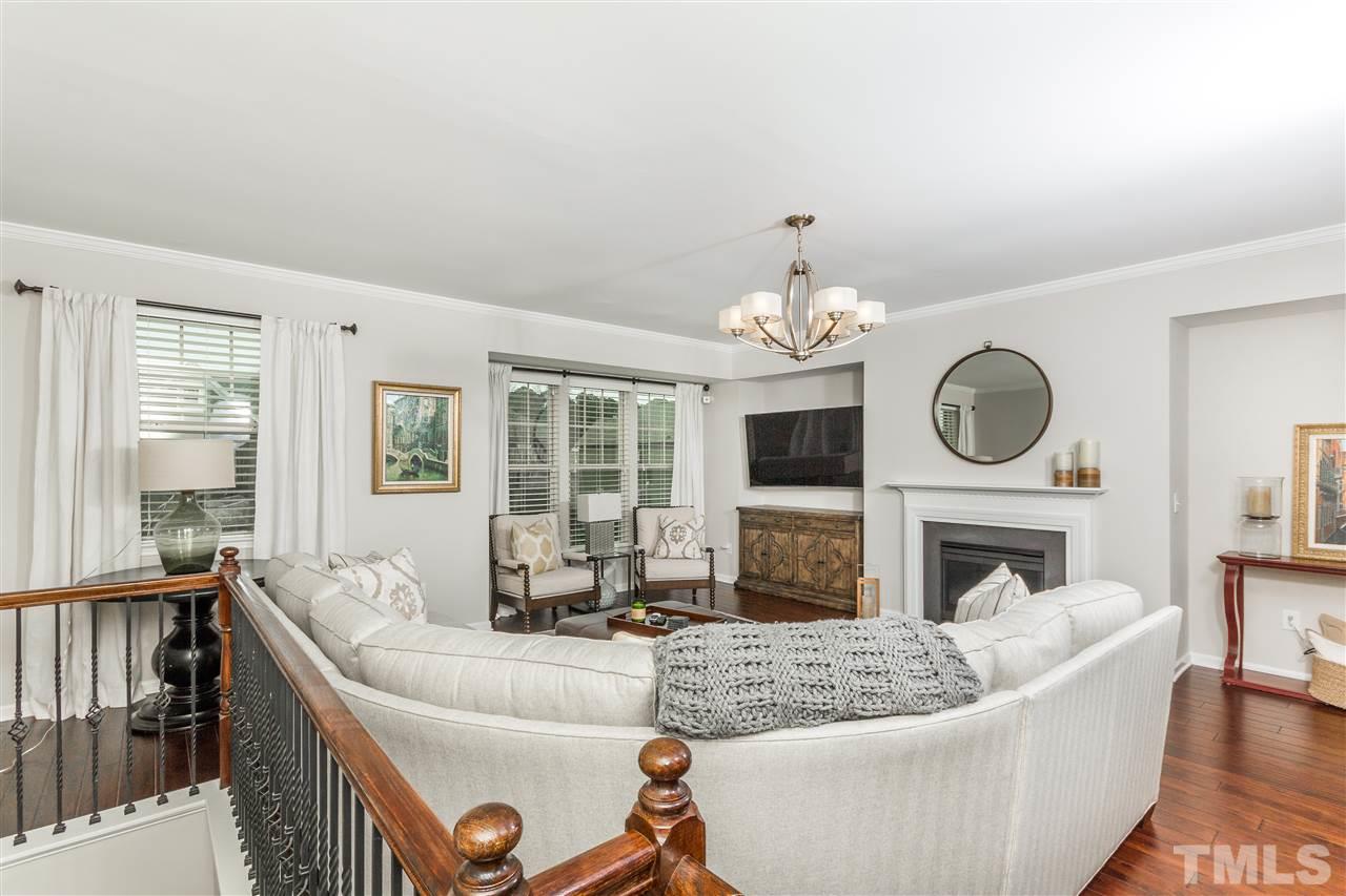 1325 Rodessa Run Raleigh, NC 27607 - Photo 2 of 25 a living room with furniture a fireplace and a chandelier