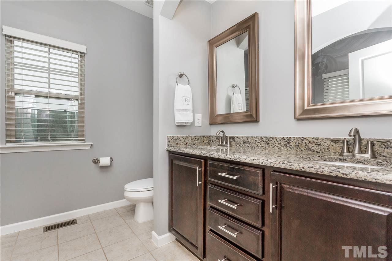 1325 Rodessa Run Raleigh, NC 27607 - Photo 16 of 25 a bathroom with a granite countertop sink a toilet and a mirror