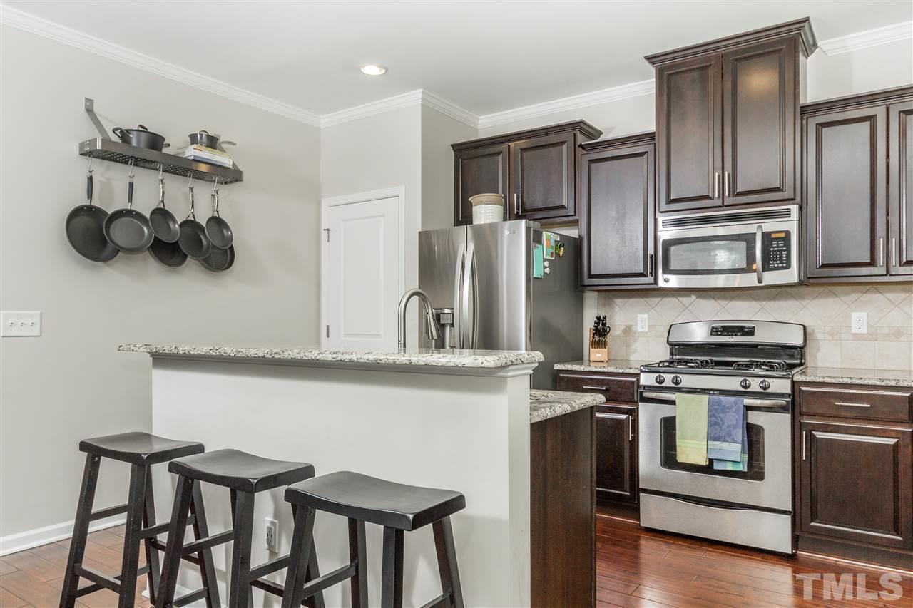 1325 Rodessa Run Raleigh, NC 27607 - Photo 8 of 25 a kitchen with stainless steel appliances granite countertop a stove a sink and a refrigerator