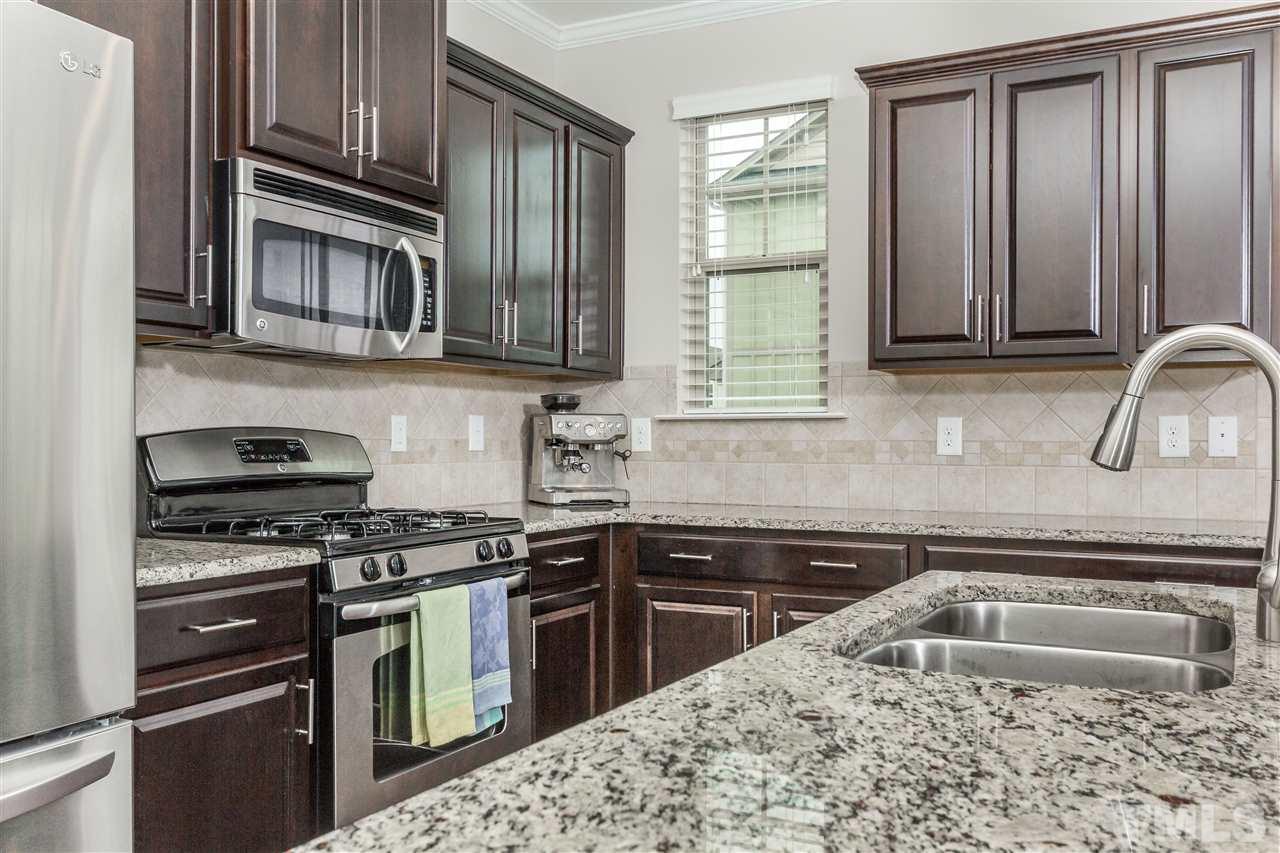 1325 Rodessa Run Raleigh, NC 27607 - Photo 9 of 25 a kitchen with stainless steel appliances granite countertop a sink stove and microwave