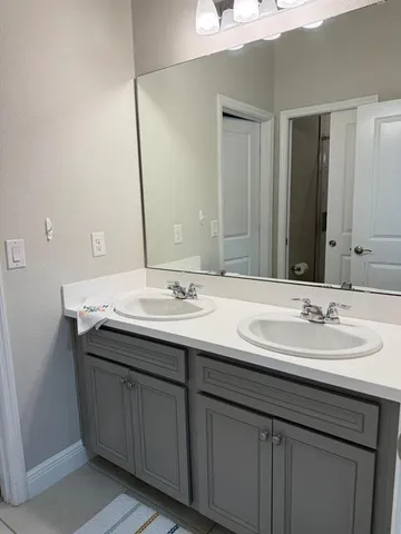 a bathroom with a double vanity sink and a mirror